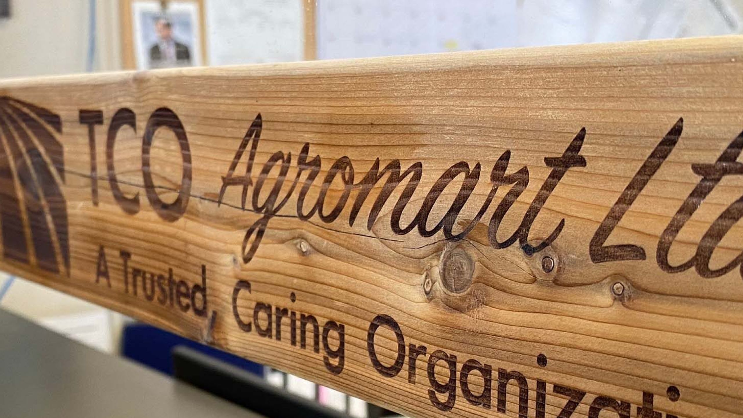 wood sign displaying TCO agromart logo